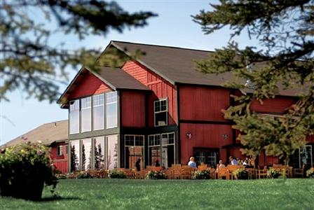 Copper River Princess Wilderness Lodge red building with tall windows and tables and chairs in front on a patio Copper River Princess Wilderness Lodge