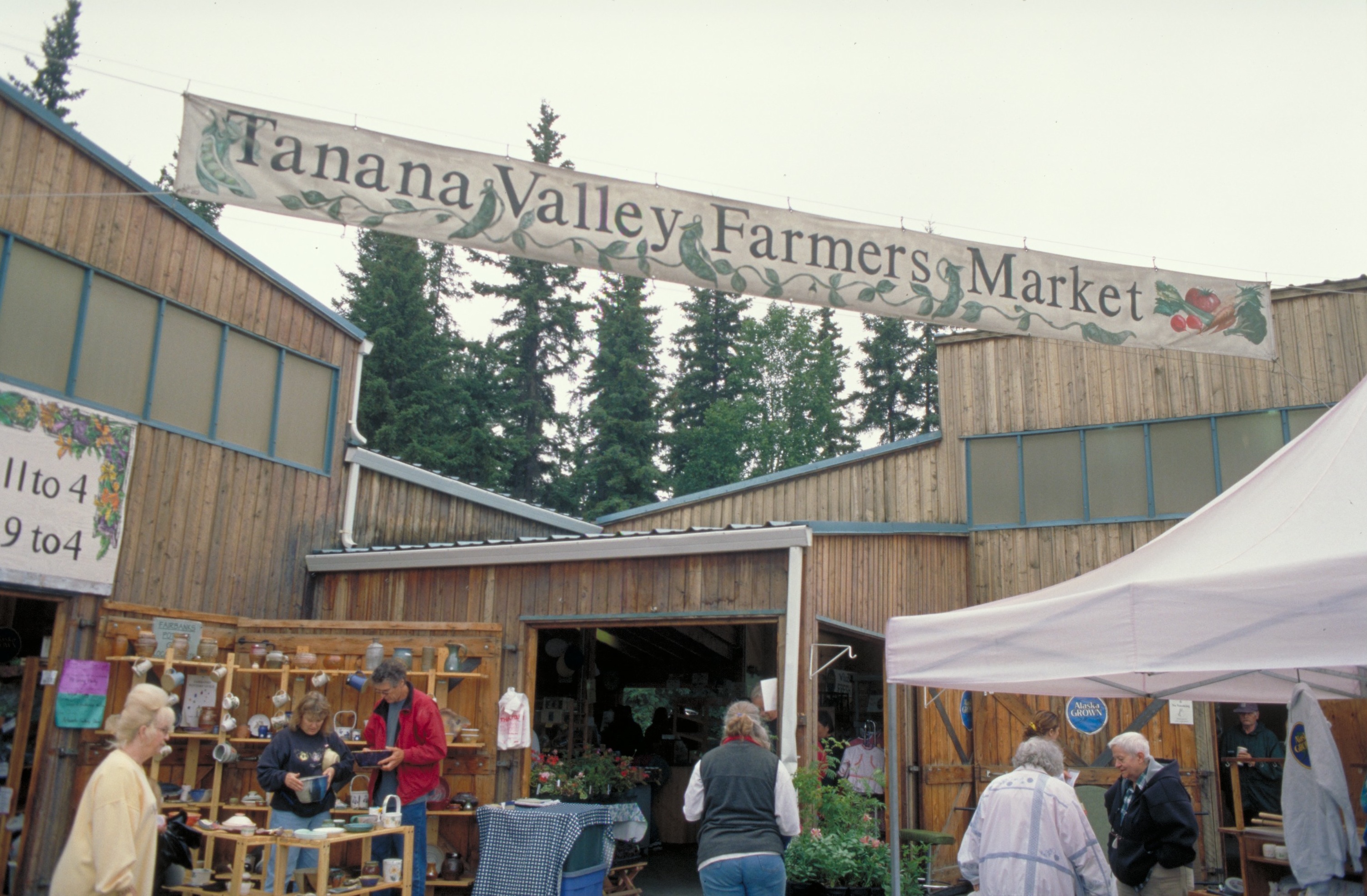 Tanana Valley Farmers Market in Fairbanks, Alaska. Tanana Valley Farmers Market hangs over tents and tables with local vendors